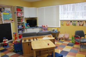 Children's activity area in shelter with toys and seated areas with a tv.