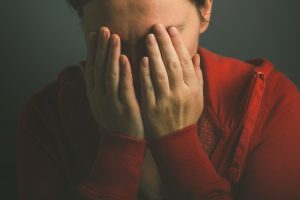 Human Trafficking Awareness Day image of a women crying in despair while covering her face with her hands.