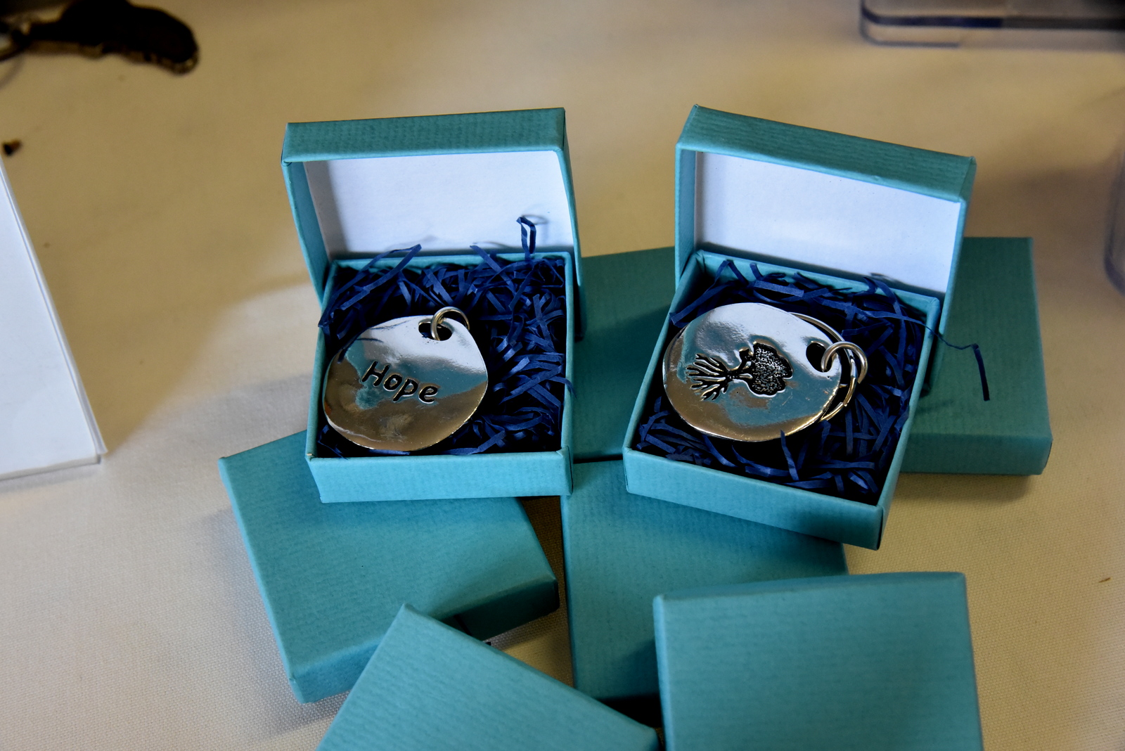 Hope Keychains in turquoise boxes at Heidi's Walk for Hope September 2023.