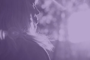 Close up silhouette of woman looking into sunset with purple screen
