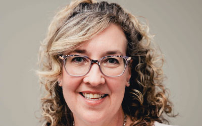 Headshot of Family Transition Place's Executive Director Lynette Pole-Langdon in cream sweater standing in front of cream background